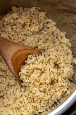 Brown Rice in the instant pot with wooden spoon.