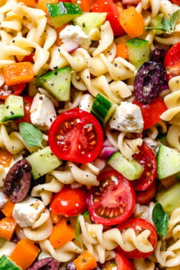 Greek Pasta Salad is light and fresh, loaded with garden tomatoes, bell peppers and cucumbers tossed in a homemade Greek dressing with Kalamata olives and Feta cheese. Perfect for summer parties!